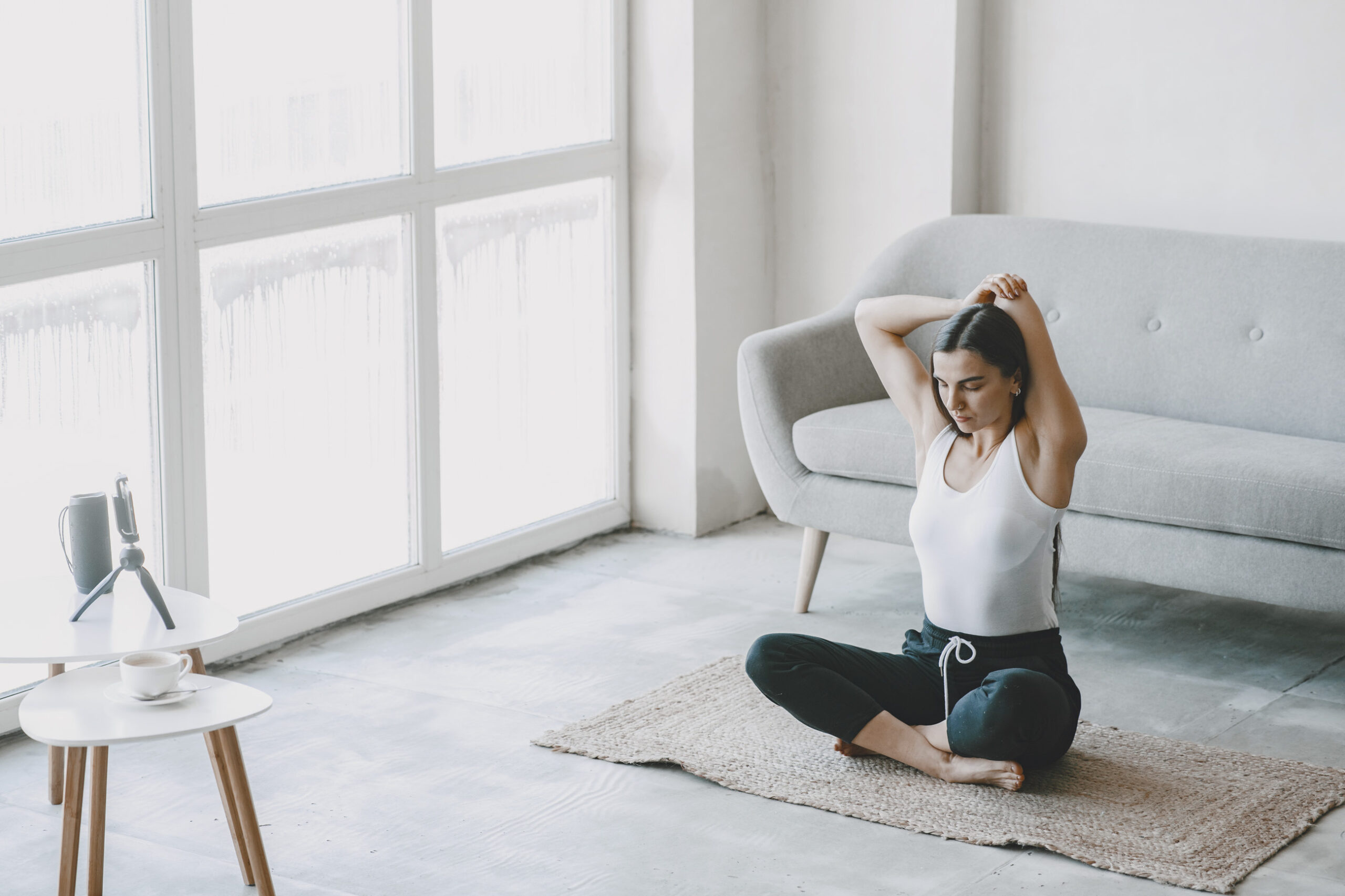 Girl doing yoga online with phone and music at home